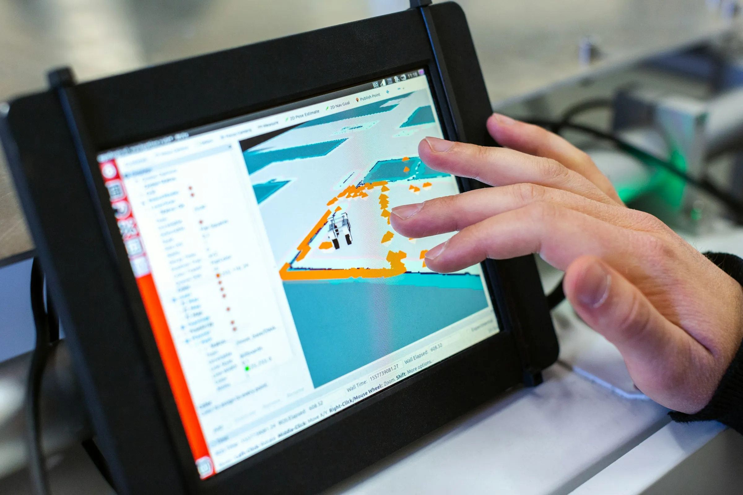 Hand bedient ein Industrie-Tablet mit Steuerungssoftware in einer Werkstatt
