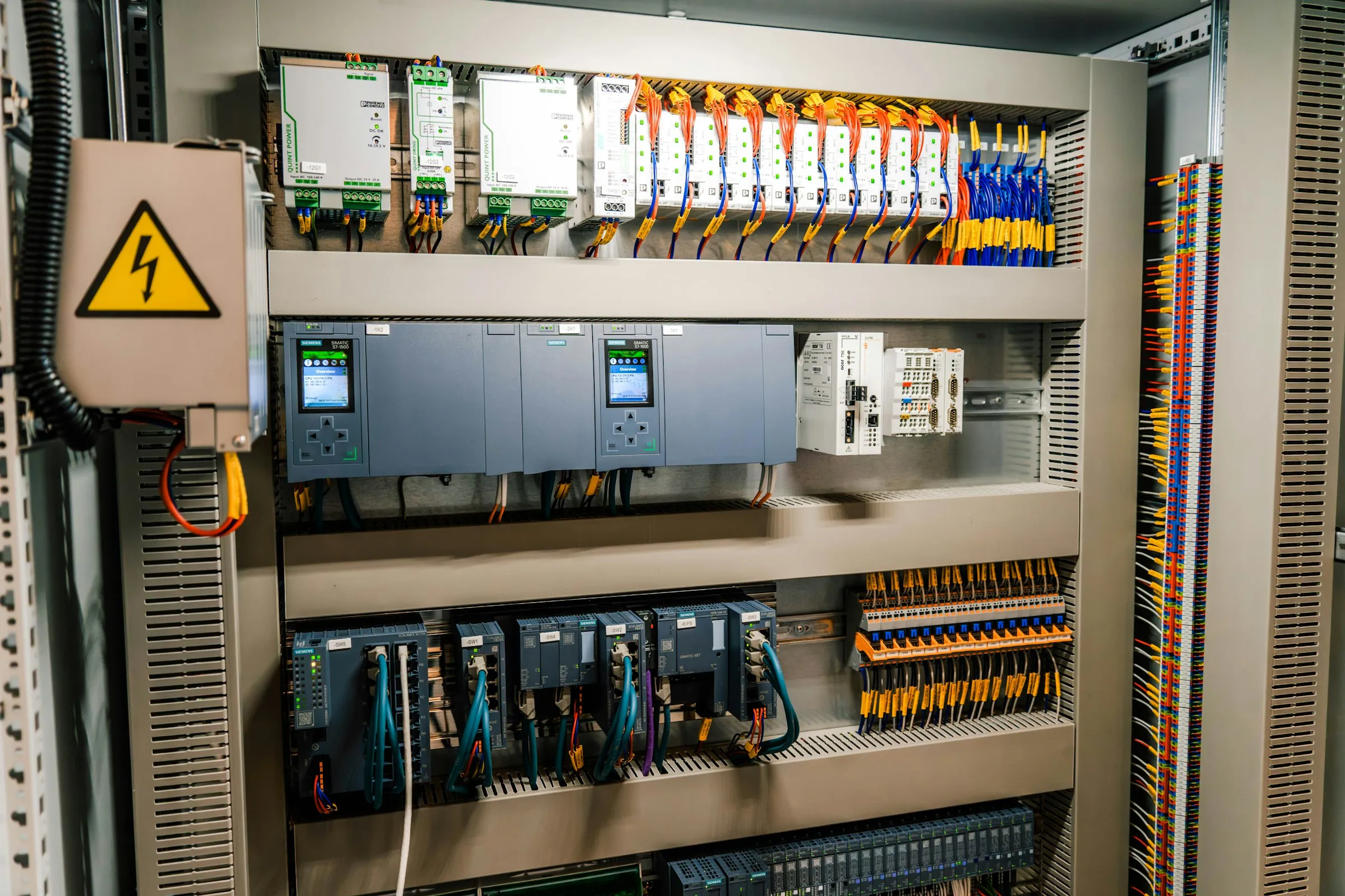 Offener Schaltschrank mit SPS-Modulen, Netzteilen und Reihenklemmen
