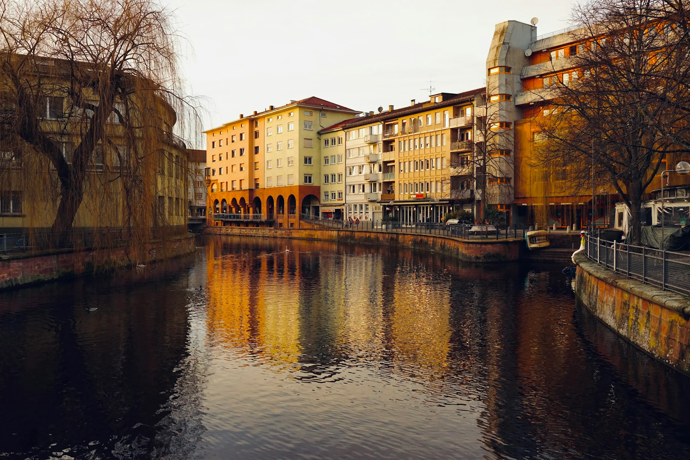 Häuser am Ufer der Enz in Pforzheim spiegeln sich im Abendlicht